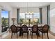 Formal dining room with a large table, a modern chandelier, and natural light from the large window at 14582 Mission Walk Loop, Parker, CO 80134