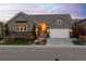 Charming single-Gathering home with a well-maintained lawn, a two-car garage, and stone accents at twilight at 14582 Mission Walk Loop, Parker, CO 80134