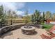Inviting stone fire pit area with built-in seating, mature trees, and scenic backyard views, ideal for outdoor gatherings at 14582 Mission Walk Loop, Parker, CO 80134