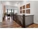 Bright open hallway with hardwood floors, decorated with wood art, overlooks the living room at 14582 Mission Walk Loop, Parker, CO 80134