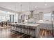 Modern kitchen with a large center island, quartz countertops, stainless steel appliances, and pendant lighting at 14582 Mission Walk Loop, Parker, CO 80134