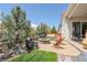 Landscaped patio with a stone fire pit, modern outdoor furniture, and lush greenery at 14582 Mission Walk Loop, Parker, CO 80134