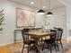 Dining room featuring a rustic wooden table, modern lighting, and neutral decor at 2454 S Gilpin St, Denver, CO 80210