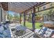 Backyard patio with outdoor furniture under a shaded pergola with a trampoline and garden area at 10694 Cedarcrest Cir, Highlands Ranch, CO 80130