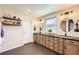 Modern bathroom features dual vanities, wood cabinets, subway tile backsplash, and black slate tile flooring at 10694 Cedarcrest Cir, Highlands Ranch, CO 80130