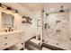 This updated bathroom boasts a gorgeous shower with white marble tile, floating shelves, and new fixtures at 10694 Cedarcrest Cir, Highlands Ranch, CO 80130
