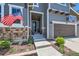 Inviting front entrance with American flag, well-kept landscaping and a dark wooden garage door at 10694 Cedarcrest Cir, Highlands Ranch, CO 80130