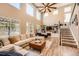 Spacious living room with large windows, high ceilings, modern decor, and a cozy fireplace at 10694 Cedarcrest Cir, Highlands Ranch, CO 80130