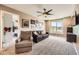 A cozy living area features neutral tones, a comfortable sofa and chair, and multiple framed wall pictures at 10694 Cedarcrest Cir, Highlands Ranch, CO 80130
