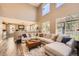 Bright and airy living room with large windows, high ceilings, and modern sectional sofa at 10694 Cedarcrest Cir, Highlands Ranch, CO 80130