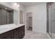 Modern bathroom featuring double sink vanity, tiled floor, and glass-enclosed shower at 3961 Happy Hollow Dr, Castle Rock, CO 80104