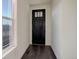 Modern entryway with a black front door, sleek dark wood floors, white walls and trim, and natural light at 3961 Happy Hollow Dr, Castle Rock, CO 80104