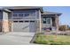 Inviting two-story home featuring stone accents, a gray facade, attached two car garage, and a well-manicured lawn at 3961 Happy Hollow Dr, Castle Rock, CO 80104