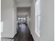 Bright hallway with dark wood floors and white walls leading to an open-concept living and dining area at 3961 Happy Hollow Dr, Castle Rock, CO 80104