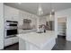 Bright kitchen with stainless steel appliances, quartz countertops, herringbone tile backsplash, and pantry at 3961 Happy Hollow Dr, Castle Rock, CO 80104