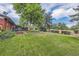 Expansive backyard with a deck, lush lawn, and mature trees at 7112 S Platte Canyon Dr, Littleton, CO 80128