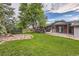 Expansive backyard featuring well-maintained lawn, patio, garden and mature trees at 7112 S Platte Canyon Dr, Littleton, CO 80128