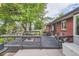 Brick house featuring an outdoor deck with a table, chairs, and umbrella perfect for outdoor entertaining at 7112 S Platte Canyon Dr, Littleton, CO 80128
