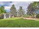 Well-maintained backyard with lush lawn, rock garden, storage shed and mature trees at 7112 S Platte Canyon Dr, Littleton, CO 80128