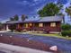 A charming brick home with solar panels, well-maintained landscaping, and a paved driveway at 7112 S Platte Canyon Dr, Littleton, CO 80128