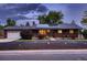 Charming brick home with manicured landscaping, solar panels, and attached garage at 7112 S Platte Canyon Dr, Littleton, CO 80128