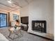 Inviting living room featuring a painted brick fireplace and access to the patio at 7112 S Platte Canyon Dr, Littleton, CO 80128