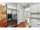 Stainless steel refrigerator in kitchen with wood floors and white cabinets at 8056 Meadowdale Sq, Niwot, CO 80503