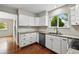 Modern kitchen with white cabinets, stainless steel dishwasher, and hardwood floors at 8056 Meadowdale Sq, Niwot, CO 80503