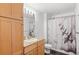 Classic bathroom with light wood cabinets, granite countertops, and airplane themed shower curtain at 1950 N Logan St # 601, Denver, CO 80203