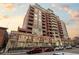 Upscale building featuring brick exterior, balconies, and parking, set against a vibrant sunset sky at 1950 N Logan St # 601, Denver, CO 80203