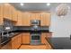 The modern kitchen boasts stainless steel appliances, black countertops, and classic wood cabinets at 1950 N Logan St # 601, Denver, CO 80203
