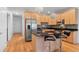 Open concept kitchen with stainless steel appliances, light wood cabinetry, island, and modern pendant lighting at 1950 N Logan St # 601, Denver, CO 80203
