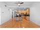 Open floorplan with kitchen island, stainless appliances, wood cabinets, modern lighting, and hardwood floors at 1950 N Logan St # 601, Denver, CO 80203