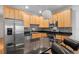 Kitchen with stainless steel appliances, wood cabinets, black countertop, and island with bar stool seating at 1950 N Logan St # 601, Denver, CO 80203