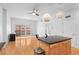 Open living room and kitchen area featuring hardwood floors, ceiling fan, kitchen island, and sliding door to balcony at 1950 N Logan St # 601, Denver, CO 80203
