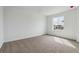 Bright bedroom featuring neutral carpet, white walls, and natural light from a window at 9652 Cathay St, Commerce City, CO 80022