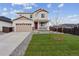 Inviting two-story home with a well-manicured lawn and a charming front porch; the perfect place to welcome guests at 9652 Cathay St, Commerce City, CO 80022