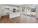 Contemporary kitchen with white cabinets, stainless steel appliances, an island, and sliding glass doors to the backyard at 9652 Cathay St, Commerce City, CO 80022