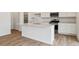 Elegant kitchen featuring white cabinets, stainless steel appliances, and a quartz countertop island at 9652 Cathay St, Commerce City, CO 80022
