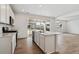 Bright, open-concept kitchen with white cabinets, stainless steel appliances, and hardwood floors at 9652 Cathay St, Commerce City, CO 80022