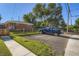Spacious backyard with a gravel parking area, wooden fence, lush greenery, and a classic brick home at 2497 S Race St, Denver, CO 80210