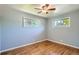 Bedroom with hardwood floors, two windows offering natural light, and a ceiling fan for added comfort at 2497 S Race St, Denver, CO 80210