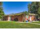 Charming brick home with a well-maintained lawn and a clear blue sky on a sunny day at 2497 S Race St, Denver, CO 80210
