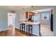 Bright kitchen with wooden cabinets, a breakfast bar with pendant lights, and an adjoining living area at 2497 S Race St, Denver, CO 80210