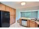 Kitchen featuring wood cabinets, black appliances, tile flooring, and a breakfast bar with granite countertops at 2497 S Race St, Denver, CO 80210