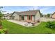 Well-maintained backyard with a concrete patio, lush grass, and charming stone accents at 5193 Rustic Ave, Firestone, CO 80504