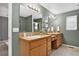 Bathroom features double vanity with wood cabinets, neutral walls, and a glass shower at 5193 Rustic Ave, Firestone, CO 80504