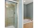 Modern tiled shower with glass door located adjacent to a soaking tub in the bathroom at 5193 Rustic Ave, Firestone, CO 80504