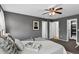 Gray bedroom with ceiling fan, carpet, and large bed with entrance to walk-in closet at 5193 Rustic Ave, Firestone, CO 80504