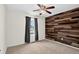 Bright bedroom featuring natural light and a charming wood accent wall with ceiling fan at 5193 Rustic Ave, Firestone, CO 80504
